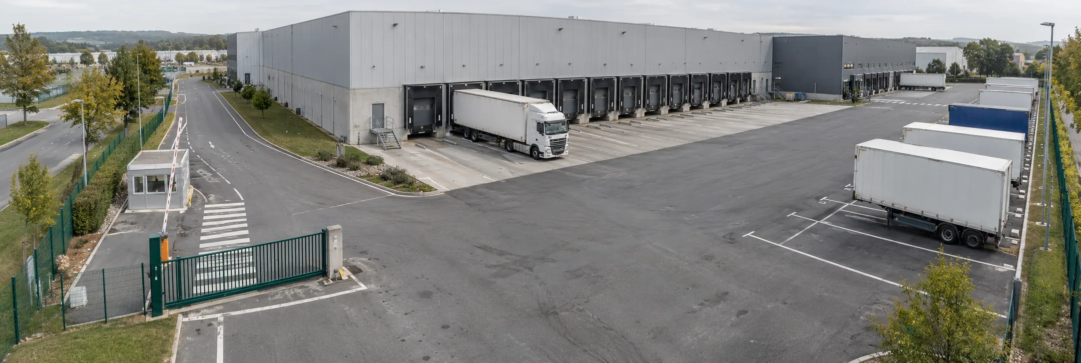 La plateforme logistique filmée par le dôme : portail, quais et parking poids lourds